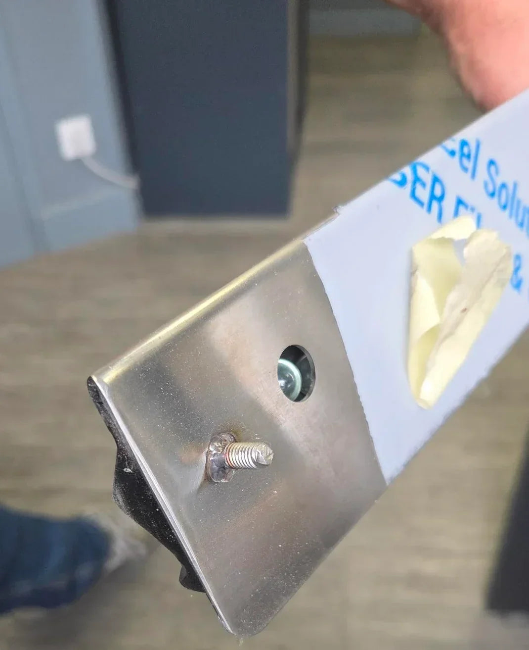 Extrémité de la barre à bons en inox de JMC INOX : une bille de verre MesBilles de 12/14 mm logée dans le profil retient un document