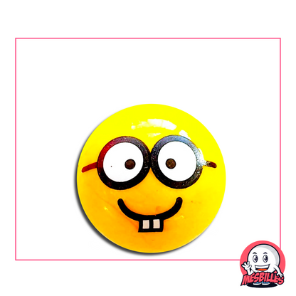 Bille jaune avec un visage souriant portant de grosses lunettes rondes et deux dents visibles
