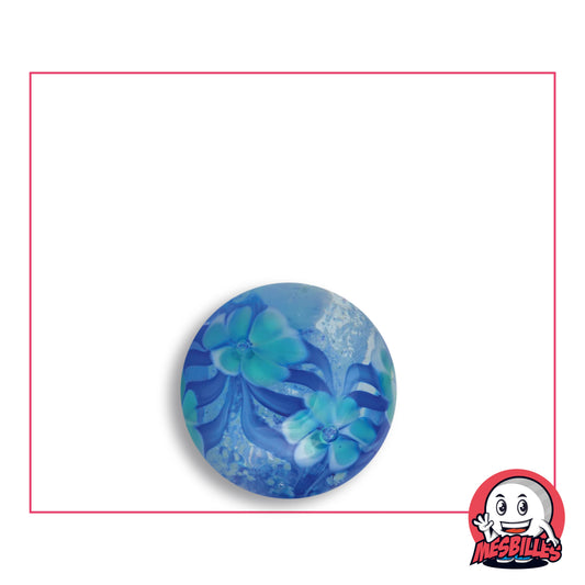 Bille Art Jardin Fleuri Phosphorescent en verre transparent nuancé de bleu rempli de fleurs turquoise bordées de blanc, de feuillages bleus et de paillettes claires, vue de dessus, 16 mm de diamètre