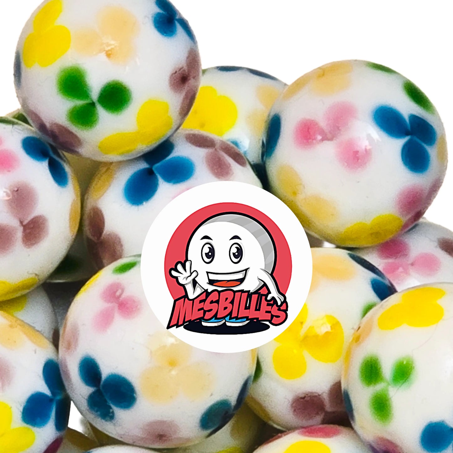 Billes sur son fond blanc immaculé s’épanouissent des fleurs colorées — jaunes, bleues, vertes et roses — qui semblent avoir été soufflées par un vent de bonne humeur.
