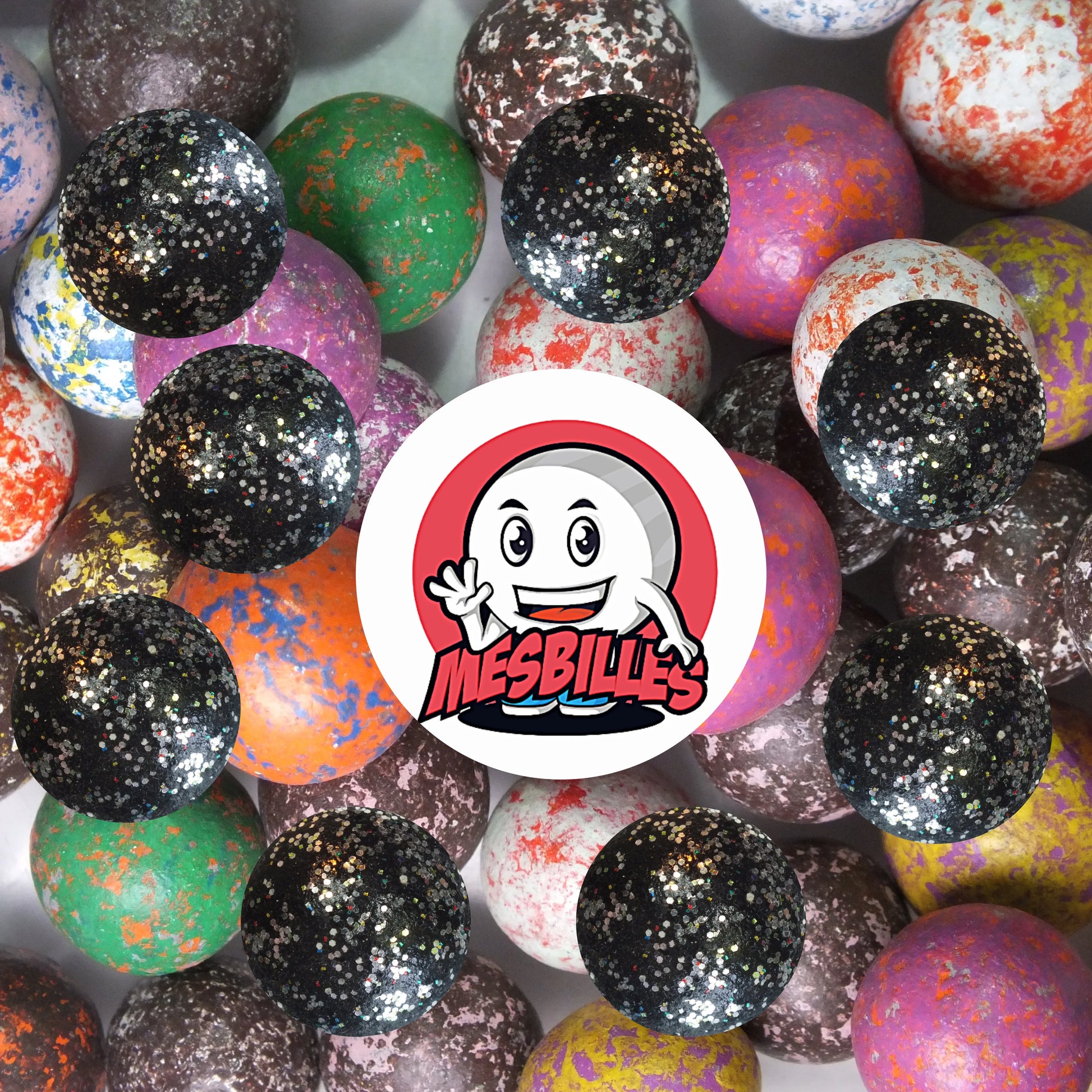 Collection de billes en terre multicolores avec plusieurs billes noir paillettes 10 mm au premier plan, ambiance festive et élégante