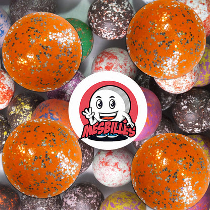 Collection de billes en terre multicolores avec plusieurs billes orange paillettes 22 mm au premier plan, ambiance joyeuse et rétro